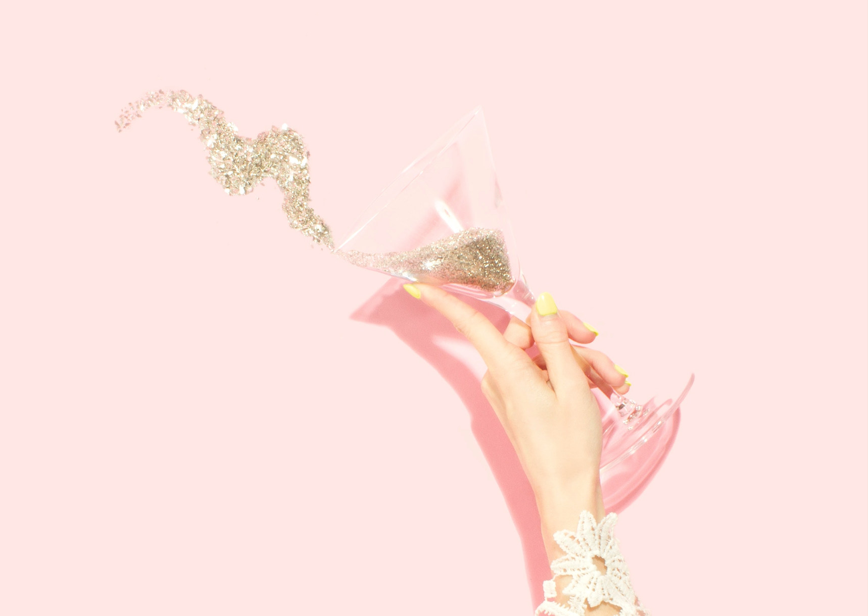 image of woman tossing glitter from martini glass